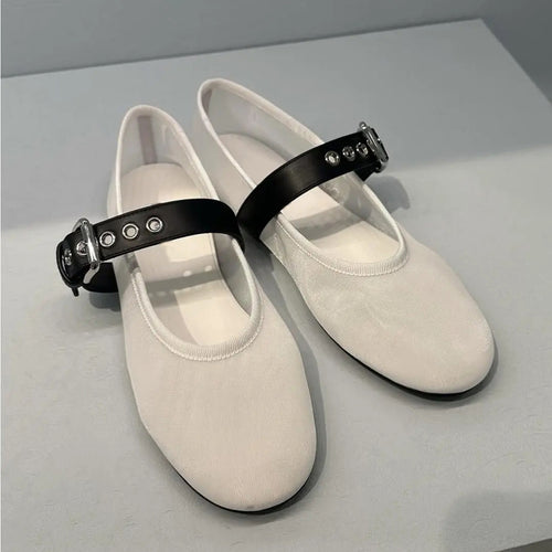 White shoes with black straps on a light gray background
